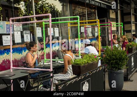 Places en plein air avec écrans protecteurs en plexiglas pendant la pandémie Covid 19 au restaurant mexicain la Cocina Oeste, New York City, NY, USA Banque D'Images