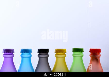 Jeu de flacons de différentes couleurs. Choix de couleurs et concept de conteneurs. Une rangée de boissons sans alcool colorées sur fond gris clair. Récipients de boissons énergétiques avec différentes saveurs, espace de copie Banque D'Images