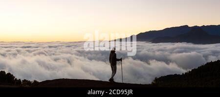 Espagne, îles Canaries, la Palma, silhouette d'un randonneur devant une mer nuageuse au coucher du soleil Banque D'Images