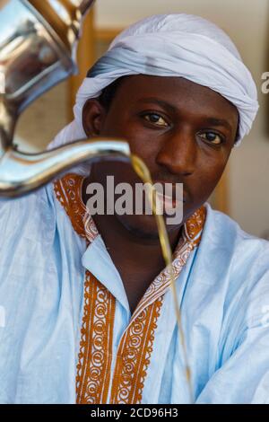 Marocco, Oued Ed-Dahab, Dakhla, les Dunes Eco-Lodge, jeune marocain servant du thé sous une tente saharoui traditionnelle Banque D'Images