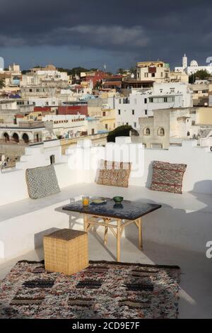 Maroc, région de Tanger Tétouan, Tanger, hôtel Dar Nour, terrasse blanche de la maison d'hôtes Dar Nour, décorée avec des coussins orientaux et une table en zelligue, surplombant la Kasbah Banque D'Images