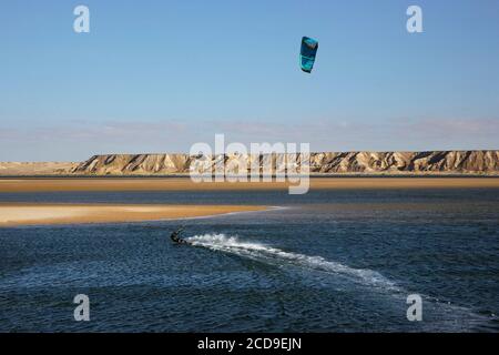 Maroc, Sahara occidental, Dakhla, kitesurfer sur le lagon, entre la dune blanche et les montagnes désertiques Banque D'Images