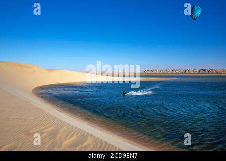 Maroc, Sahara occidental, Dakhla, kitesurfer sur le lagon, entre la dune blanche et les montagnes désertiques Banque D'Images
