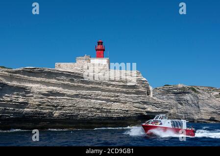 France, Corse du Sud, Bonifacio, les bateaux de promenade passent près du phare de Madonetta pour visiter la grotte de Sdragonato dont l'ouverture sur le ciel représente l'île de Corse Banque D'Images