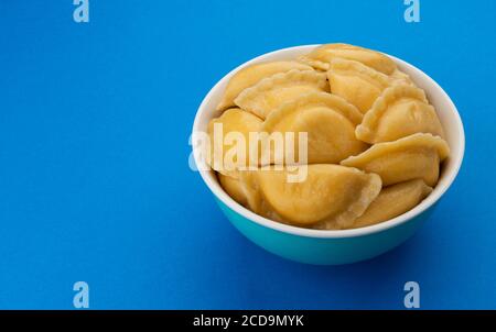 Boulettes remplies, vareniki russe, pelmeni sur fond bleu Banque D'Images