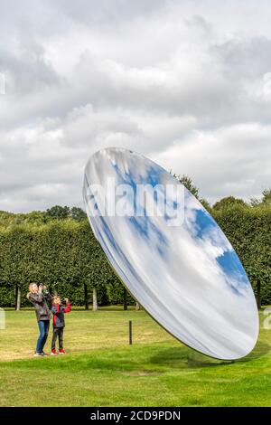 Visiteurs appréciant Sky Mirror par Anish Kapoor dans le domaine de Houghton Hall, Norfolk. Acier inoxydable, 2018. Banque D'Images