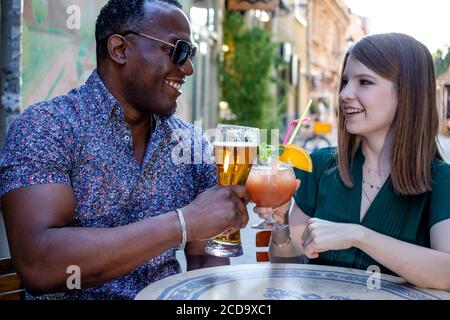 Des amis multiraciaux boivent et toastent sur la terrasse du café. Concept d'amitié avec les jeunes multi-ethniques appréciant le temps ensemble. Banque D'Images