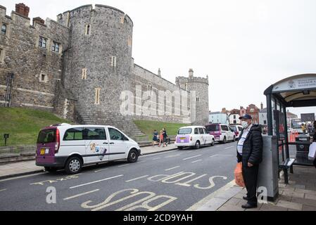 Windsor, Royaume-Uni. 27 août 2020. Un homme qui attend un autobus en face du château de Windsor porte un revêtement de visage pour aider à prévenir la propagation du coronavirus. Tessa Lindfield, directrice de la santé publique du Berkshire, a exhorté les résidents du Royal Borough of Windsor et de Maidenhead à suivre les directives de distanciation sociale suite à une augmentation significative du nombre de tests positifs de COVID-19 dans ce pays au cours de la semaine dernière. Crédit : Mark Kerrison/Alamy Live News Banque D'Images