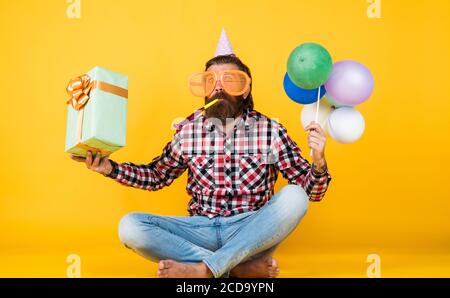 tout pour moi. amusez-vous en fête. préparez-vous pour les vacances. Event Manager pose avec un accessoire festif. Concept amusant et heureux. Homme heureux tenant des ballons d'hélium colorés. hipster souriant joyeusement. Banque D'Images