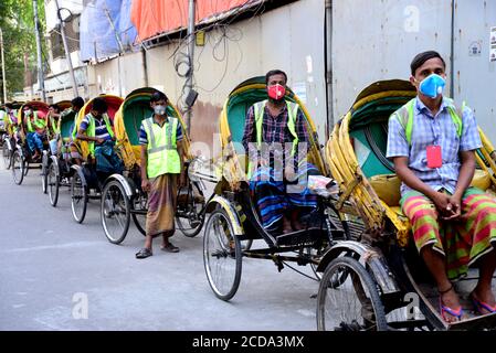 Les conducteurs de Rickshaw du Bangladesh attendent les passagers lors d'un confinement imposé par le gouvernement comme mesure préventive contre le coronavirus COVID-19 à Dhaka, B Banque D'Images