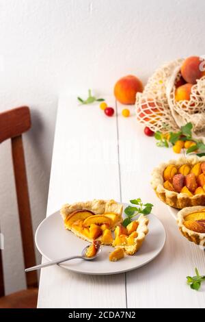 Délicieux morceau de tarte de pâte à croûte courte avec pêche sur une assiette avec une fourchette, cuit dans le four pêche clafoutis Banque D'Images