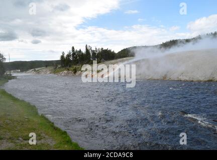 Fin du printemps dans le parc national de Yellowstone : la rivière Firehole traverse le bassin Geyser de Midway le long de la route Grand Loop Banque D'Images