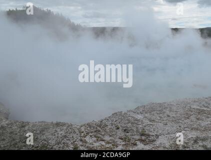 Fin du printemps dans le parc national de Yellowstone : la vapeur dense s'élève du cratère Excelsior Geyser dans le bassin de Midway Geyser Banque D'Images