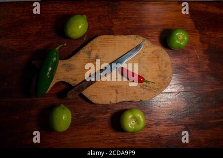 Vue de dessus d'une planche à découper avec un couteau et quelques légumes Banque D'Images