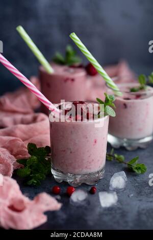 Verres de smoothie aux baies sur fond sombre. Banque D'Images