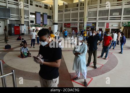 Les voyageurs bangladais ont fait la queue pour maintenir des attentes sociales de distanciation afin de recueillir des billets à la gare de Kamalapur à Dhaka, au Bangladesh, le 30 mai 2 Banque D'Images