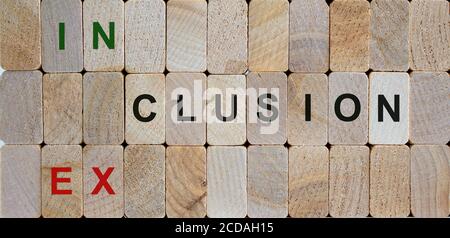 Les blocs en bois forment les mots « inclusion, exclusion ». Magnifique arrière-plan en bois. Image de concept. Banque D'Images
