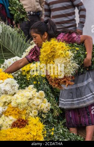 Une femme maya Quiche vend des fleurs sur le marché des fleurs sur les marches mayas pré-hispanique devant l'église de Santo Tomas à Chichichastenango, Gua Banque D'Images