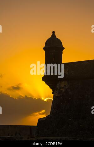 Un bartizan, ou une guérilla ou une boîte de sentry sur le mur de Castillo San Felipe del Morro dans le vieux San Juan, Porto Rico, est silhouetté contre le ciel de coucher du soleil Banque D'Images