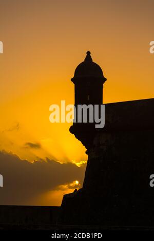 Un bartizan, ou une guérilla ou une boîte de sentry sur le mur de Castillo San Felipe del Morro dans le vieux San Juan, Porto Rico, est silhouetté contre le ciel de coucher du soleil Banque D'Images
