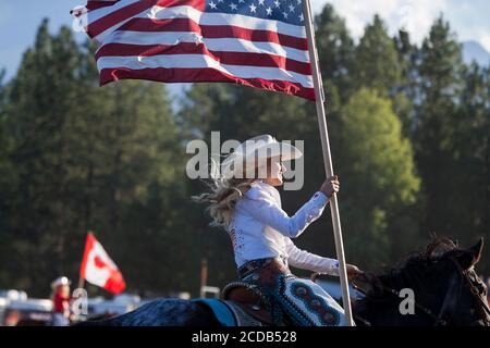 Miss Last chance Rodeo Queen Cassie Turner présente les couleurs lors de la cérémonie d'ouverture du Kootenai River Stampede à Libby, Montana, le vendredi 24 juillet 2020. Le rodéo annuel a été organisé avec des mesures de sécurité supplémentaires en place en raison de la hausse des cas de COVID-19 dans l'État. Banque D'Images