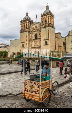 Un vendeur vendant des élotes et des esquites dans la rue du centre historique d'Oaxaca, au Mexique. Les Elotes sont du maïs sur l'épi qui sont d'abord bouillis, alors Banque D'Images