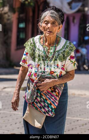 Une femme maya de niveau inférieur Tzutujil en robe traditionnelle descend la rue à San Pablo la Laguna, Guatemala. Banque D'Images