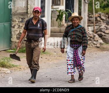 Deux fermiers mayas marchant vers leurs champs près de San Pedro la Laguna, Solola, Guatemala. L'homme plus âgé porte la robe traditionnelle de la ville, wh Banque D'Images