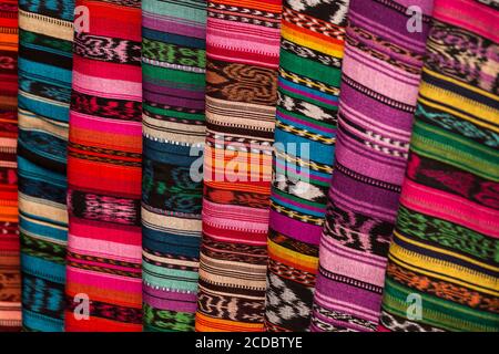 Un étalage de tzutes ou de chiffons traditionnels à vendre dans le marché ouvert hebdomadaire à Santiago Atitlan, au Guatemala. Ils sont faits à la main sur une traditio Banque D'Images