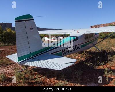 Deux Cessna 185 Skywagons de l'Utah Backcountry Pilots Association garés sur la piste d'atterrissage à fond minéral dans le canyon de Labyrinth, près de Moab, dans l'Utah. Banque D'Images