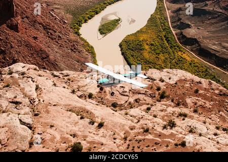 Un Cessna 180 Skywagon de l'Utah Backcountry Pilots Association survole la rivière Green à Labyrinth Canyon près de Moab, Utah. Banque D'Images