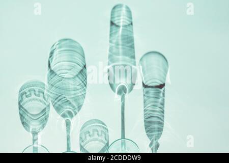 Des verres à vin sur une table ensoleillée jettent des ombres, la lumière du soleil, la verrerie en cristal, les verres à vin, la flûte à champagne. Banque D'Images