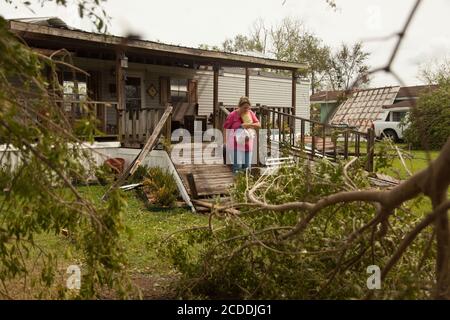 Soufre, Louisiane, États-Unis. 27 août 2020. SANDRA ANCELET saisit des produits d'épicerie de son congélateur et les charge dans un wagon. Elle a dû se garer à l'entrée de sa subdivision à cause des arbres et des lignes électriques en panne, et espère sauver la nourriture avant qu'ils ne se mettent à mal. Elle a fait un pas dans la tempête dans un hôtel local, et elle fera un barbecue pour les clients. L'ouragan Laura a frappé la frontière entre la Louisiane et le Texas en tant qu'ouragan de catégorie 4, laissant un sillage de destruction sur son chemin. Crédit : Leslie Spurlock/ZUMA Wire/Alay Live News Banque D'Images