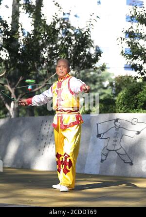 (200828) -- BEIJING, 28 août 2020 (Xinhua) -- Dong Shulin joue du diabolo sur la place de la culture Wukesong Diabolo à Beijing, capitale de la Chine, 11 août 2020. Dong Shulin, 66 ans, vit avec sa femme Mei Yongpei et sa petite-fille de 9 ans Dong Yutong à Beijing. Dong Shulin a commencé à jouer au diabolo en 2003 et maintenant toute la famille aime jouer à ce jeu folklorique traditionnel, dans lequel on peut jeter et attraper un haut tournant en déplaçant un cordon attaché à deux bâtons. Dans la maison de Dong Shulin, plus de 70 diabolos ont été placés tout autour. Certains des diabolos ont été achetés et d'autres ont été faits maison, en particulier Banque D'Images