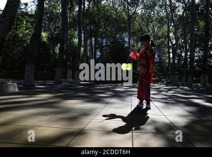 (200828) -- BEIJING, 28 août 2020 (Xinhua) -- Dong Yutong joue du diabolo sur la place de la culture Wukesong Diabolo à Beijing, capitale de la Chine, 11 août 2020. Dong Shulin, 66 ans, vit avec sa femme Mei Yongpei et sa petite-fille de 9 ans Dong Yutong à Beijing. Dong Shulin a commencé à jouer au diabolo en 2003 et maintenant toute la famille aime jouer à ce jeu folklorique traditionnel, dans lequel on peut jeter et attraper un haut tournant en déplaçant un cordon attaché à deux bâtons. Dans la maison de Dong Shulin, plus de 70 diabolos ont été placés tout autour. Certains des diabolos ont été achetés et d'autres ont été faits maison, en particulier Banque D'Images