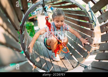 Parc de corde. L'enfant passe l'obstacle dans le parc de corde. Banque D'Images