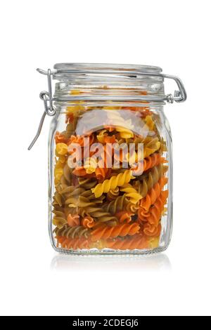 Pâtes Tricolor fusilli dans un pot en verre isolé sur fond blanc. Banque D'Images