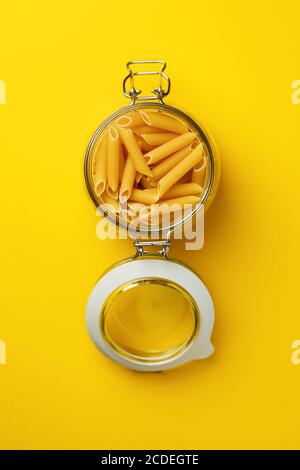 Pâtes dans un pot en verre vue du dessus sur fond jaune. Banque D'Images