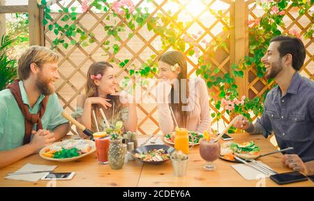 Les jeunes couples mangent un brunch et boivent un saladier à millésime Bar - des gens heureux qui discutent dans un restaurant branché - Tendances alimentaires et amour Banque D'Images