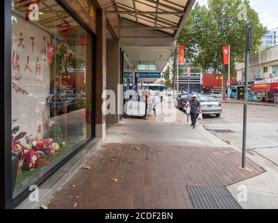 Vue sur un trottoir dans la banlieue de Chatswood, dans le nord inférieur Façade de la rive et des commerces de détail pendant un été nuageux après-midi Banque D'Images