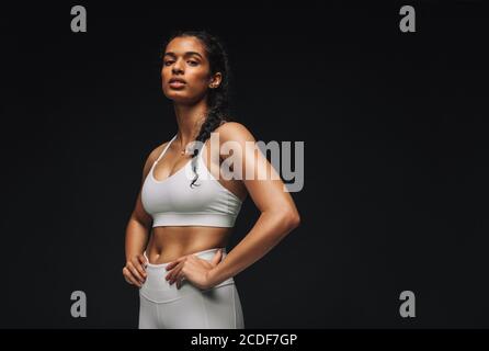 Portrait rapproché d'une athlète féminine confiante. Femme en forme de femme blanche porter debout avec les mains à la taille. Banque D'Images