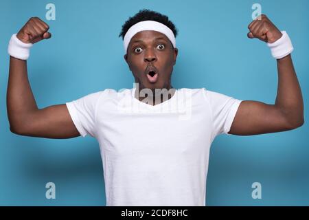 homme africain se sentant fort se levant poing vers le haut, montrant ses muscles Banque D'Images