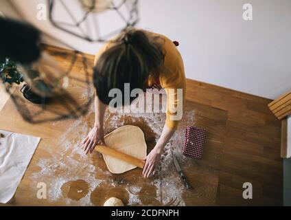 Vue en grand angle de la femme pétriant de la pâte à pain dans la cuisine tableau Banque D'Images