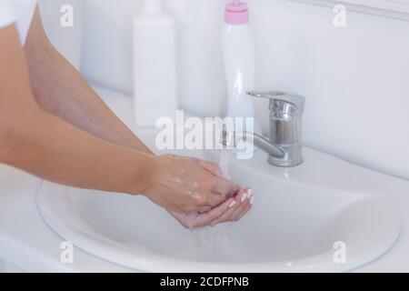Gros plan de la femme se laver les mains avec du savon liquide Banque D'Images
