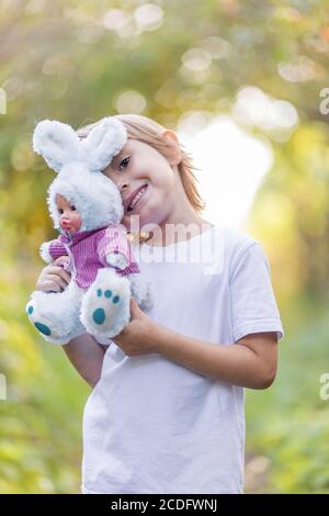 Adorable petite fille adorable avec un jouet de lapin moelleux en peluche. Banque D'Images