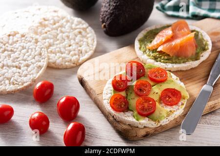 Gâteau de riz soufflé avec avocat et tomate sur table en bois Banque D'Images