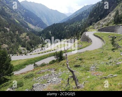 Longue route sinueuse menant à travers des montagnes boisées Banque D'Images