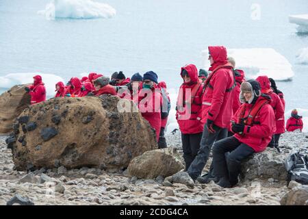 Touristes du navire de croisière G Expedition observant une colonie de pingouins d'Adlie sur Brown Bluff, Antarctique Banque D'Images