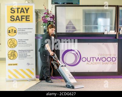 Une femme nettoie à l'Outwood Academy Shafton à Barnsley, dans le Yorkshire du Sud, pendant que les préparatifs sont faits avant le début du nouveau terme. Banque D'Images