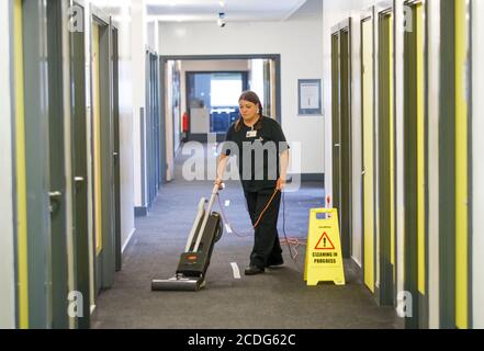 Une femme nettoie à l'Outwood Academy Shafton à Barnsley, dans le Yorkshire du Sud, pendant que les préparatifs sont faits avant le début du nouveau terme. Banque D'Images